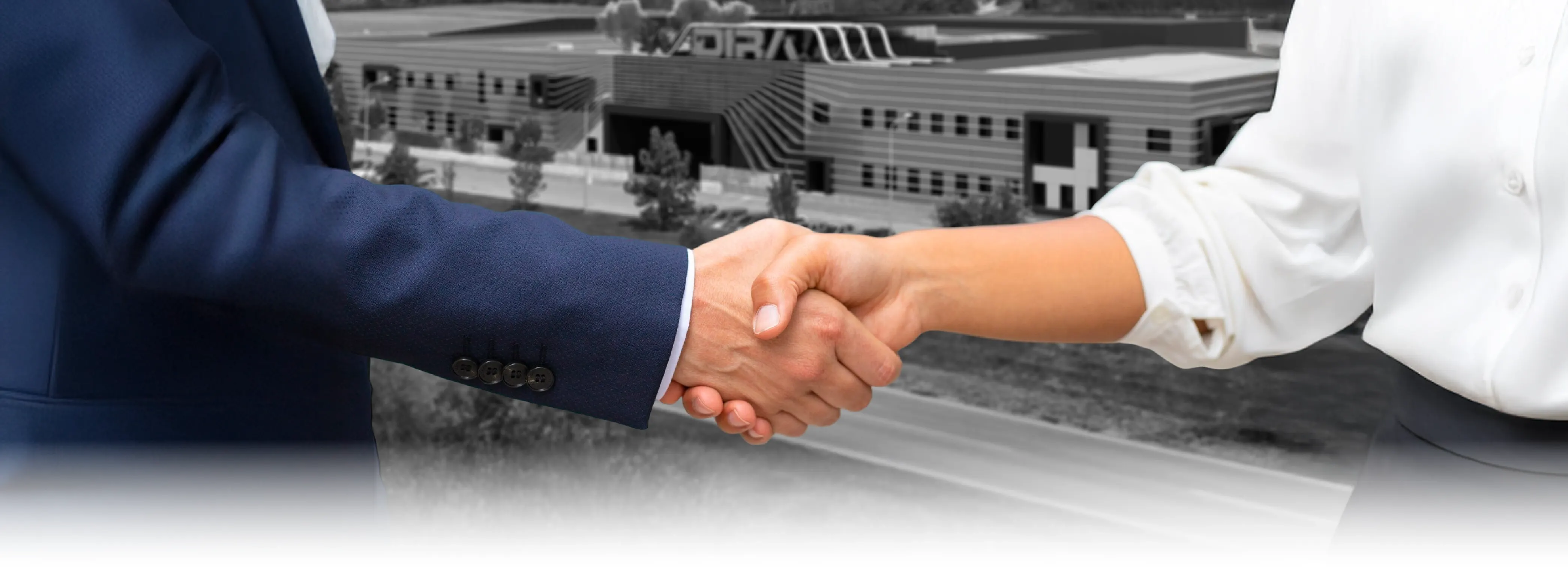 Persone che si stringono la mano con sullo sfondo la sede Dira di Cervere