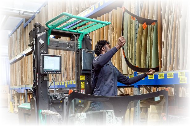 Lavoratore in magazzino Dira che sposta un vetro